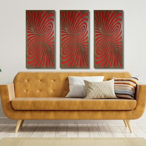 May include: Three red and brown abstract wall art panels with a swirling pattern. The panels are hanging on a white wall above a brown couch.