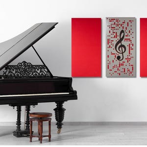 May include: A black grand piano with a decorative music stand and a small stool. Red panels and a panel with a treble clef hang on the wall. The piano has ornate legs and a detailed music rack.