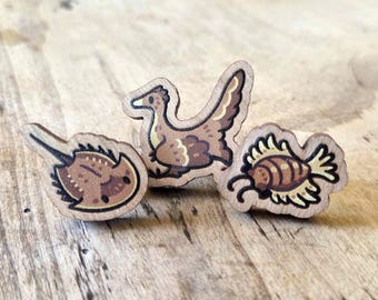 Mini pines de madera de criaturas prehistóricas: cangrejo herradura, Archaeopteryx y Anomalocaris.