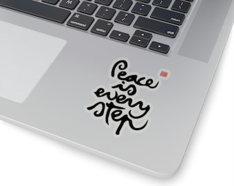May include: A black and white sticker with the text "Peace is every step" on a silver laptop.