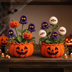 Może przedstawiać: Dwie szydełkowane doniczki w kształcie dyni z różnymi roślinami o tematyce Halloween. Jedna doniczka zawiera pomarańczowe dynie i fioletowe kwiaty przypominające duchy, a druga białe głowy owinięte jak mumie oraz fioletowe kwiaty z żółtymi oczami.
