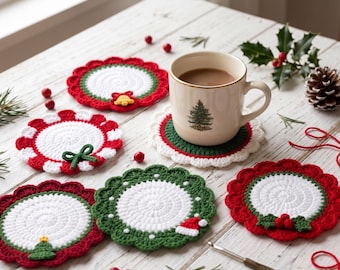 May include: Five round crocheted coasters featuring holiday motifs including a yellow bell, a green bow, a small green tree, a red and white Santa hat, and red berries. A cream-colored ceramic mug with a Christmas tree print sits on one coaster.