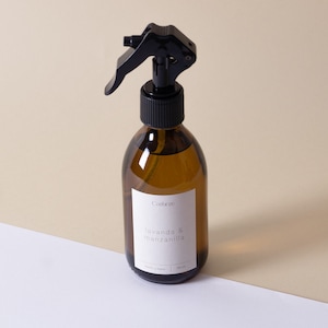 Op de afbeelding: Een bruine glazen fles met een zwarte spuitmond. De fles heeft een wit etiket met de tekst "Catifaze Lavanda & Manzanilla 200 ml".