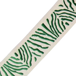 May include: White fabric ribbon with a green zebra print design.