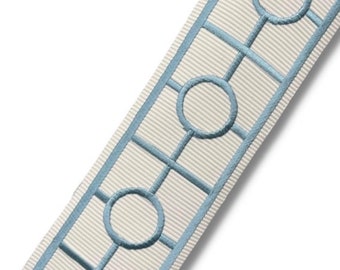 May include: White ribbon trim with a blue geometric pattern of circles and squares.