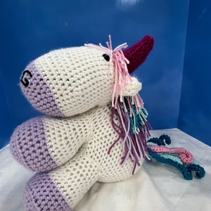 Anabelle the Unicorn.  plush crocheted unicorn with a curly tail and sparkly fur.
