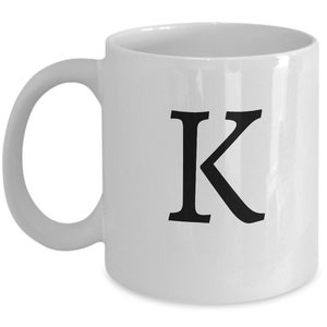 Può includere: Tazza da caffè in ceramica bianca con una lettera K nera stampata sul davanti.