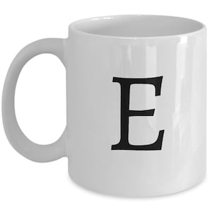 May include: White ceramic coffee mug with a black letter E printed on the front.