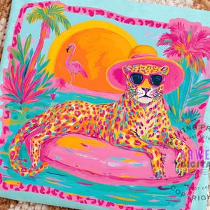 K&ouml;nnte beinhalten: Ein hellblaues T-Shirt mit einer farbenfrohen Illustration eines Leoparden mit Sonnenbrille und Hut, der auf einem rosa Schwimmer liegt. Das Design umfasst einen Sonnenuntergang, Palmen und einen Flamingo. Das Kunstwerk ist mit einem rosa Rahmen versehen.