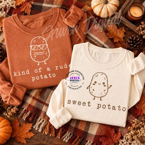 Op de afbeelding: Een roestkleurig shirt met lange mouwen met een witte afbeelding van een aardappel met een zonnebril en de tekst kind of a rude potato, en een crèmekleurig shirt met lange mouwen met een bruine afbeelding van een aardappel en de tekst sweet potato.