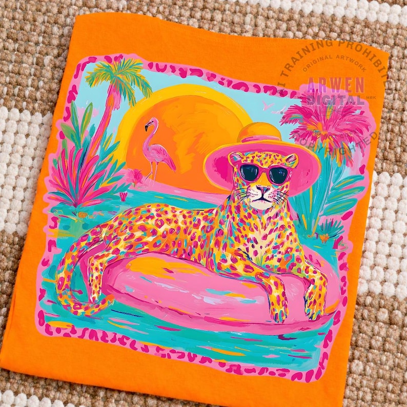 K&ouml;nnte beinhalten: Orangefarbenes T-Shirt mit einem Leoparden, der eine Sonnenbrille und einen rosa Hut tr&auml;gt und sich auf einem rosa Schwimmreifen in einer tropischen Szene entspannt. Das Design umfasst einen Flamingo, Palmen und einen Sonnenuntergang. Der Text "TRAINING PROHIBITED" und "ARWEN DIGITAL ARTWORK" ist sichtbar.