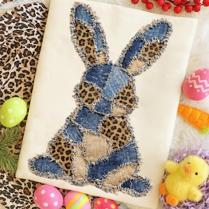 Puede incluir: Una taza de cerámica blanca con un asa negra y el texto "But First, Coffee" en negrita negra. La taza se encuentra sobre un fondo borroso, sugiriendo un ambiente acogedor.