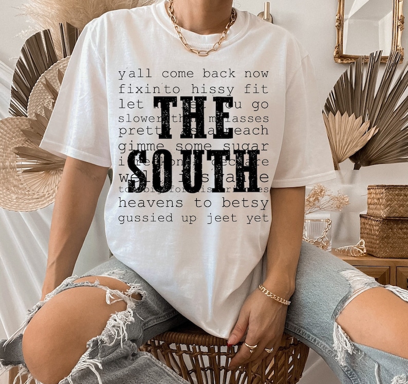 May include: White t-shirt with black text that reads "y'all come back now fixin' to hissy fit let the masses slower than each gimme some sugar  i'm proud to be from the south".