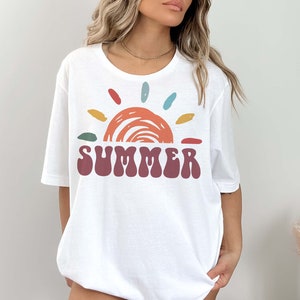 May include: White t-shirt with a colorful sun graphic and the word "SUMMER" in a retro font.