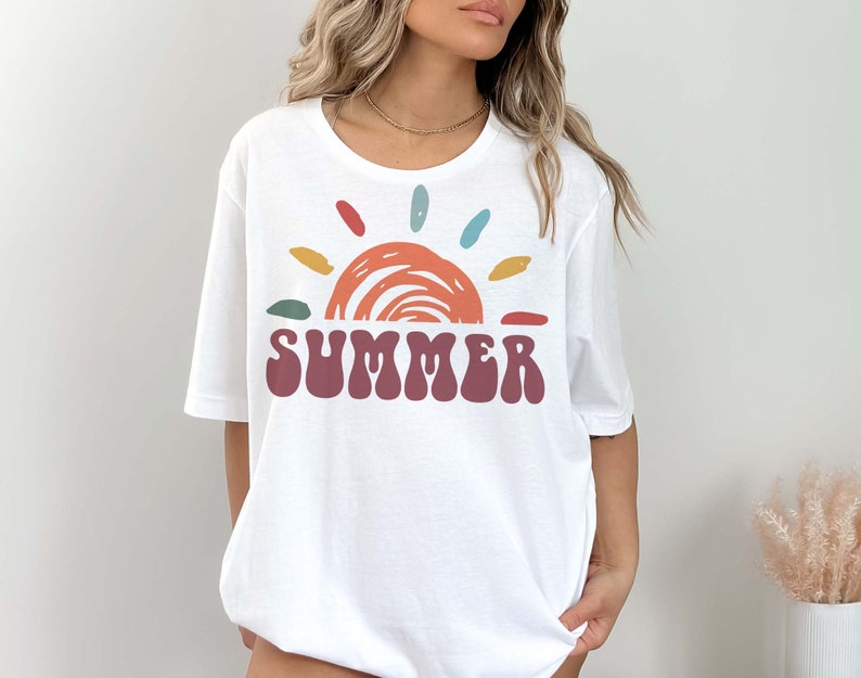 May include: White t-shirt with a colorful sun graphic and the word "SUMMER" in a retro font.