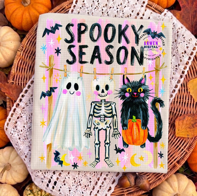 K&ouml;nnte beinhalten: Ein rechteckiger Druck mit dem Text SPOOKY SEASON in schwarzen Buchstaben. Darunter h&auml;ngen ein wei&szlig;es Gespenst, ein Skelett und eine schwarze Katze mit einem orangefarbenen K&uuml;rbis an einer W&auml;scheleine mit Holzklammern vor einem rosa gestreiften Hintergrund.