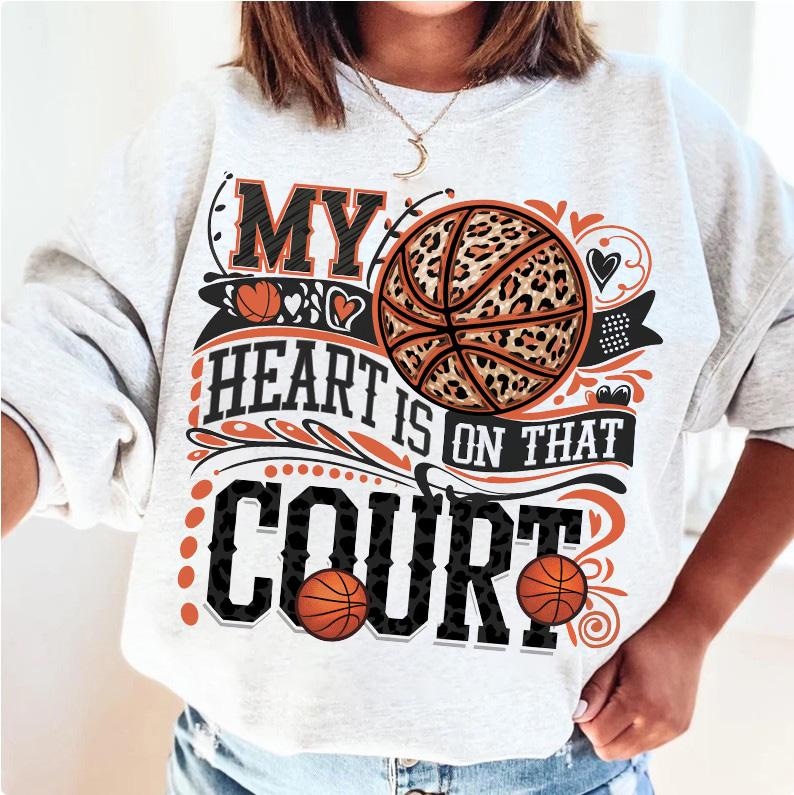 May include: A grey sweatshirt with the text "My heart is on that court" printed on it. The text is surrounded by a black and white leopard print basketball, hearts, and floral designs.