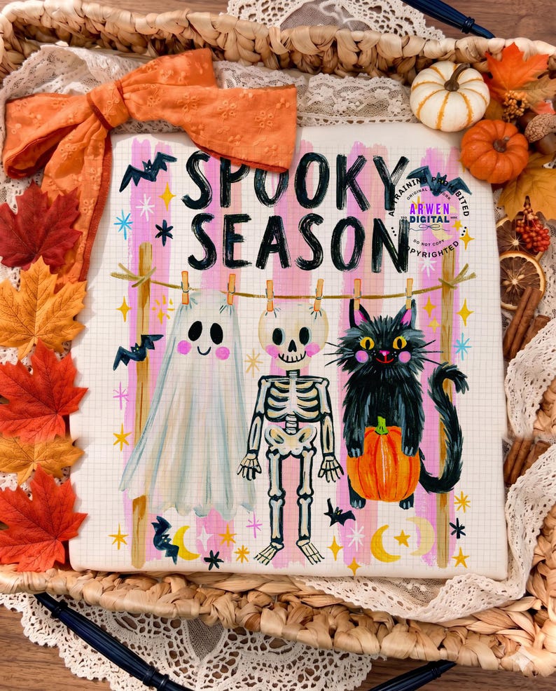 K&ouml;nnte beinhalten: Ein wei&szlig;er Stoffdruck mit dem schwarzen Schriftzug SPOOKY SEASON, der ein Gespenst, ein Skelett und eine schwarze Katze mit einem K&uuml;rbis an einer W&auml;scheleine zeigt. Der Hintergrund ist mit rosa Streifen, gelben Sternen und Flederm&auml;usen verziert.
