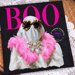 May include: A black square textile featuring the hot pink text BOO at the top. A white ghost figure is centered, wearing leopard print sunglasses and a bright pink feather boa. A large, multi-faceted clear crystal statement necklace is worn.