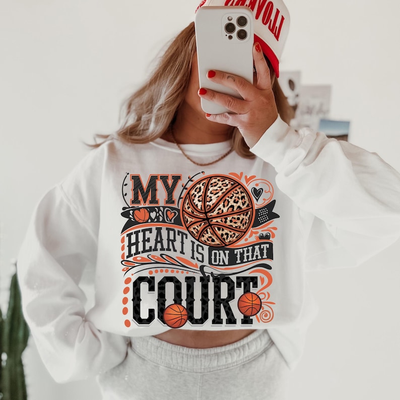 May include: White sweatshirt with a graphic print of a basketball with a leopard print design. The text on the graphic says "My heart is on that court".
