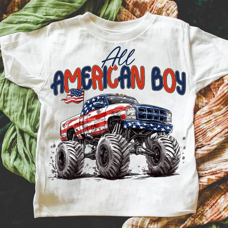 May include: White t-shirt featuring a graphic of a monster truck decorated with the American flag. The text "All AMERICAN BOY" is printed above the truck in red and blue.