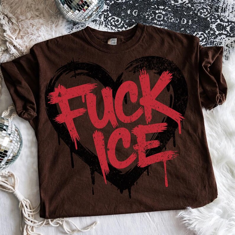 May include: Brown t-shirt with a distressed red "FUCK ICE" graphic inside a black heart shape. The shirt has a crew neck and short sleeves. The text has a dripping effect.