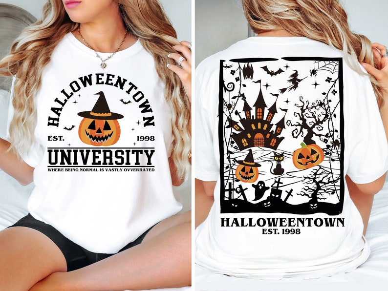 May include: White t-shirt with a Halloween design. The front displays a pumpkin in a witch's hat, the words "Halloweentown University", and the year 1998. The back shows a haunted castle, pumpkins, bats, and the text "Halloweentown Est. 1998".