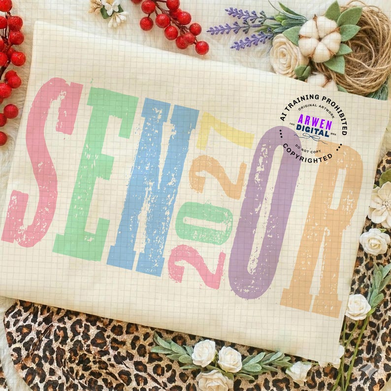 Puede incluir: Una tela de color crema con un patr&oacute;n de cuadr&iacute;cula y la palabra SENIOR 2027 impresa en una fuente desgastada y multicolor que incluye rosa, verde, azul, amarillo y morado. Un logotipo circular con el texto ARWEN DIGITAL AI TRAINING PROHIBITED es visible.
