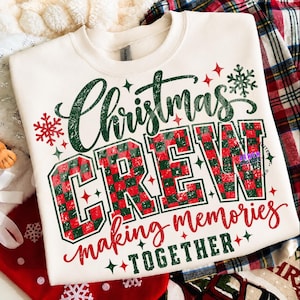 以下が含まれることがあります： クリーム色のクルーネックトレーナー。Christmas CREW making memories TOGETHERという文字がプリントされています。Christmasはダークグリーン、CREWは赤と緑のチェック柄、その他の文字は赤と緑でデザインされています。