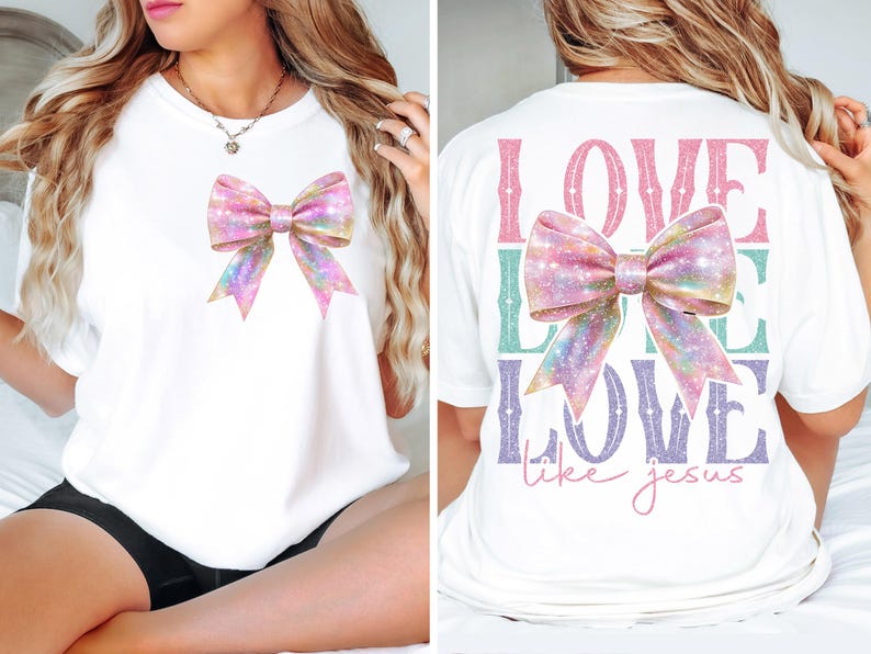 K&ouml;nnte beinhalten: Wei&szlig;es T-Shirt mit einer rosa und schillernden Schleife auf der Vorderseite und dem Text "LOVE LIKE LOVE like jesus" auf der R&uuml;ckseite.