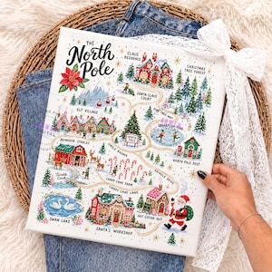 May include: A rectangular canvas print featuring a colorful illustrated map of the North Pole. The map includes labels for Claus Residence, Elf Village, Reindeer Stables, Candy Cane Farm, Santa's Workshop, and Swan Lake, with a central Santa Claus figure.