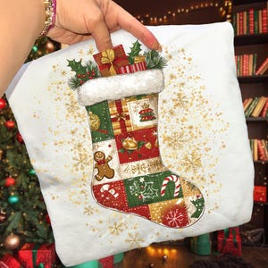 May include: A white Christmas stocking with a patchwork design featuring festive patterns and a gingerbread man. The stocking is filled with wrapped gifts and holly, with a fluffy white cuff. Gold snowflake accents are scattered across the background.