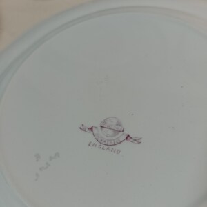 May include: A white ceramic plate with a pink and white logo that reads "Mintons Oakatrice England".