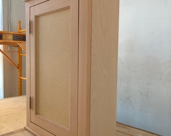 Simple, classic, over the toilet cabinet with polished brass hinges.