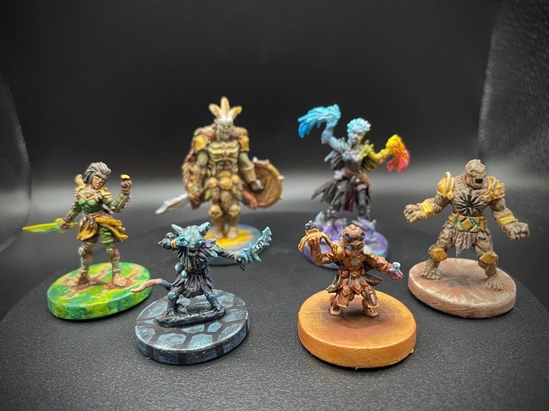 May include: Six painted miniature figures on circular bases. The figures are a green-skinned warrior with a sword, a blue-skinned figure with a staff, a brown-skinned figure with a shield, a green-skinned figure with a sword, a brown-skinned figure with a staff, and a brown-skinned figure with a sword.