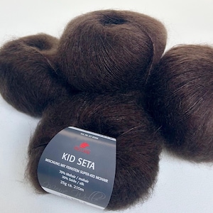 May include: Four dark brown balls of yarn made from a blend of mohair and silk. A label indicates the yarn is Kid Seta, with 70% mohair and 30% silk. Each ball weighs 25g and has approximately 210m of yarn.