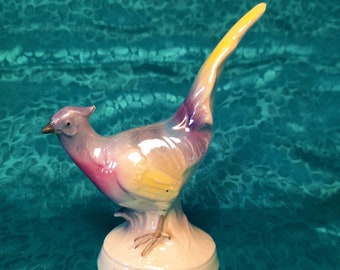 Small Bird of Paradise figurine. Multicoloured in purple, blue, green, yellow and pink, with an iridescent shine to it.