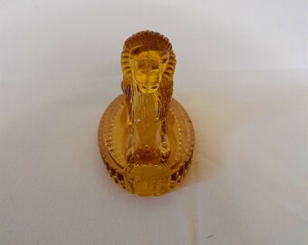 Greener & Co. amber glass seated lions, circa late 1800s early 1900s