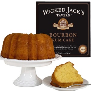 May include: A box of Wicked Jack's Tavern Bourbon Rum Cake. The box is black with gold lettering and a picture of a rum cake. The cake is a golden brown color and has a vanilla flavor. The cake is 20 ounces (560 grams).