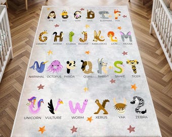 May include: A rectangular educational rug featuring the alphabet with animal illustrations. Each letter is paired with an animal, such as "Ape" for A and "Zebra" for Z. The rug has a light gray background with star accents.
