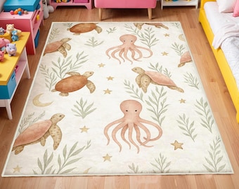 May include: A rectangular area rug with a cream background featuring watercolor illustrations of sea turtles, octopuses, seaweed, stars, and a crescent moon. The rug is designed for a child's room.