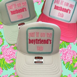 May include: Three trucker hats with different embroidered patches. The patches say "put it on my husband's tab", "put it on my boyfriend's tab", and "put it on my husband's tab".