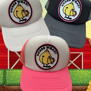 May include: Three trucker hats with a pink, white, and gray mesh back. Each hat features a yellow chicken with the text "Guess What?" in a pink circle.