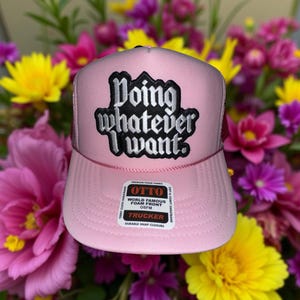 May include: Pink trucker hat with a black and white embroidered patch that says "Doing whatever I want."