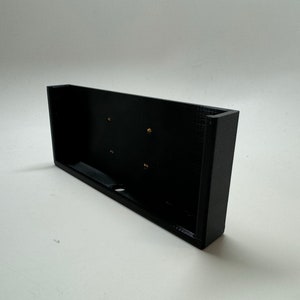 May include: Black plastic phone holder with four small holes.