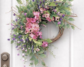 Corona floral primaveral hecha a mano con flores silvestres rosas y azules, decoración rústica para puerta.