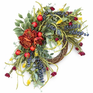 Peut inclure: Une couronne décorative composée d'une base en brindilles tressées marron, ornée de pivoines artificielles rouge foncé, de petits fruits rouges type grenades, de grappes de baies bleues, de fleurs jaunes et de feuillage vert dont de l'eucalyptus.
