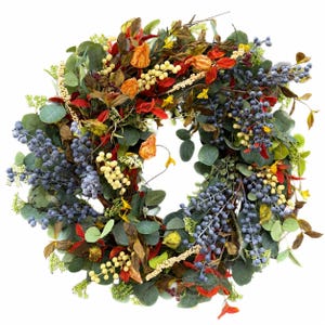Puede incluir: Una corona circular que presenta una mezcla de hojas de eucalipto verdes, racimos de pequeñas bayas azules, acentos florales de color amarillo brillante y follaje rojo oscuro. El arreglo es denso y texturizado, con elementos vegetales.