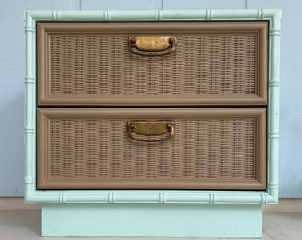 May include: A two-drawer nightstand with a light blue base and brown wicker drawers. The drawers have brass handles.