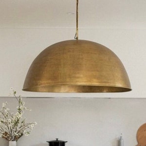 May include: A large, gold-toned, dome-shaped pendant light fixture hangs from the ceiling.